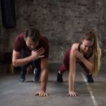 Man and woman doing calisthenics in a home gym